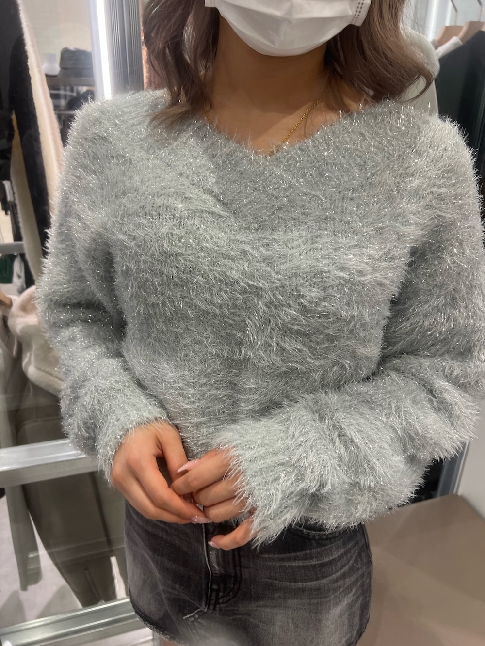 グレー系のニット/セーター、ブラック系のデニムスカート、ブラック系のブーツを着用したレディースの冬コーディネートの3枚目の写真