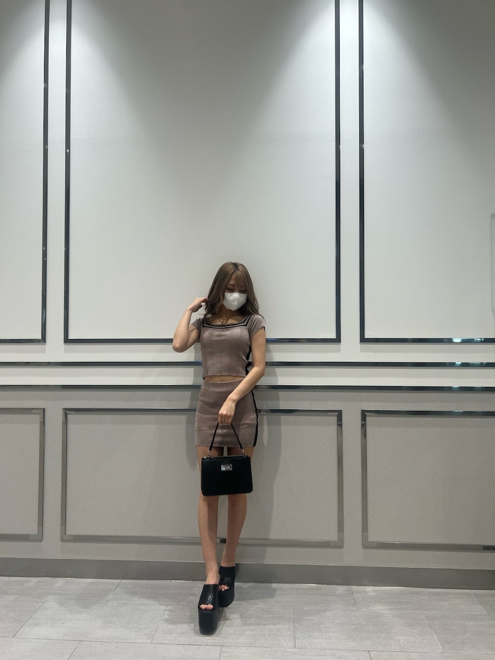 ピンク系のニット/セーター、ピンク系のスカート、ブラック系のサンダルを着用したレディースの夏コーディネートの2枚目の写真