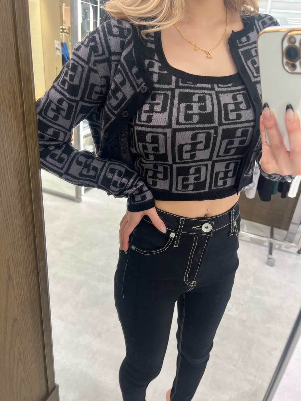 ブラック系のカーディガン/ボレロ、ブラック系のニット/セーター、ブラック系のデニムパンツを着用したレディースの春コーディネートの2枚目の写真