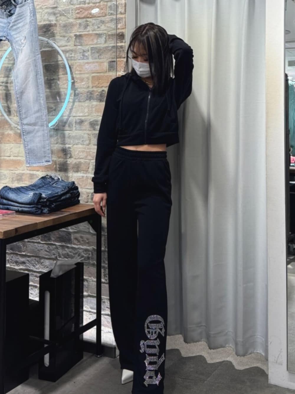 ホワイト系のパンプス、ブラック系のパーカー、ブラック系のスウェットパンツを着用したレディースの冬コーディネートの2枚目の写真