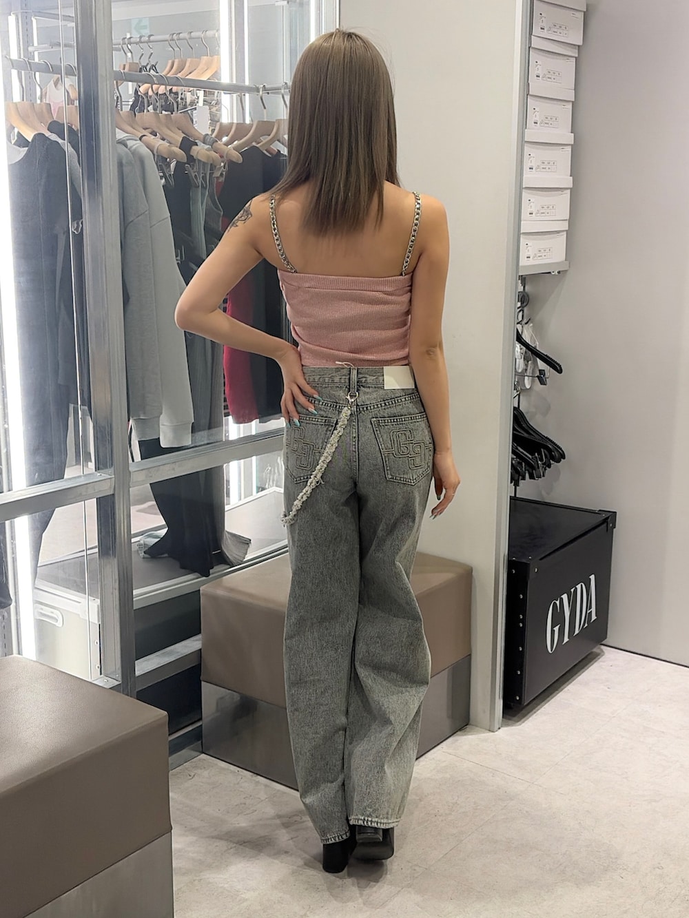 ピンク系のキャミソール、ブルー系のデニムパンツ、ブラック系のサンダルを着用したレディースの春コーディネートの2枚目の写真
