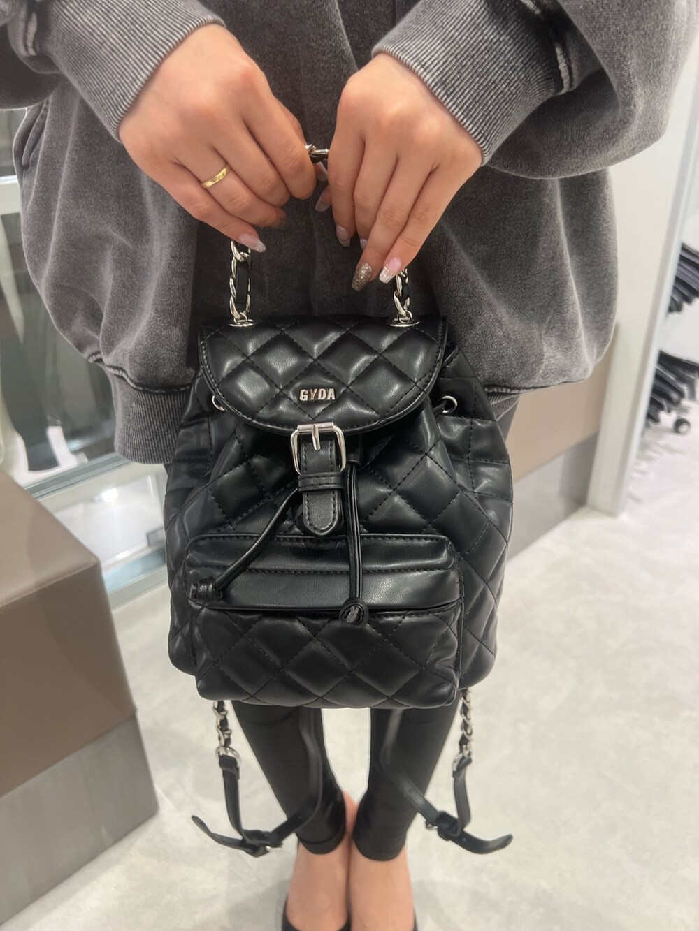 グレー系のスウェット、ブラック系のパンプス、ブラック系のレギンス/スパッツを着用したレディースの冬コーディネートの4枚目の写真