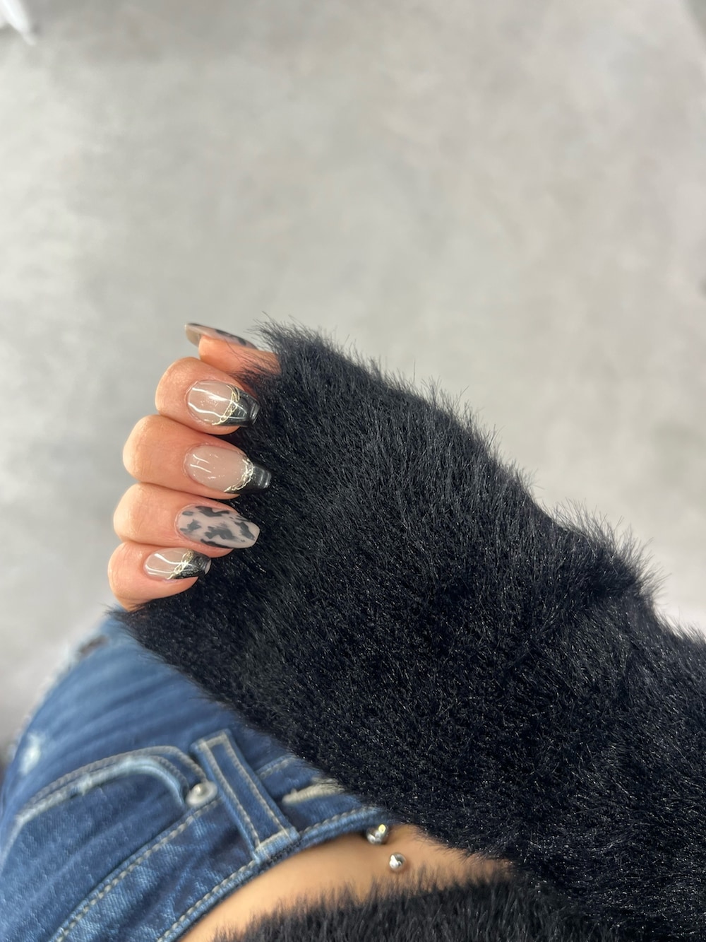 ブラック系のニット/セーター、ブルー系のデニムパンツ、ブラック系のパンプスを着用したレディースの秋コーディネートの6枚目の写真