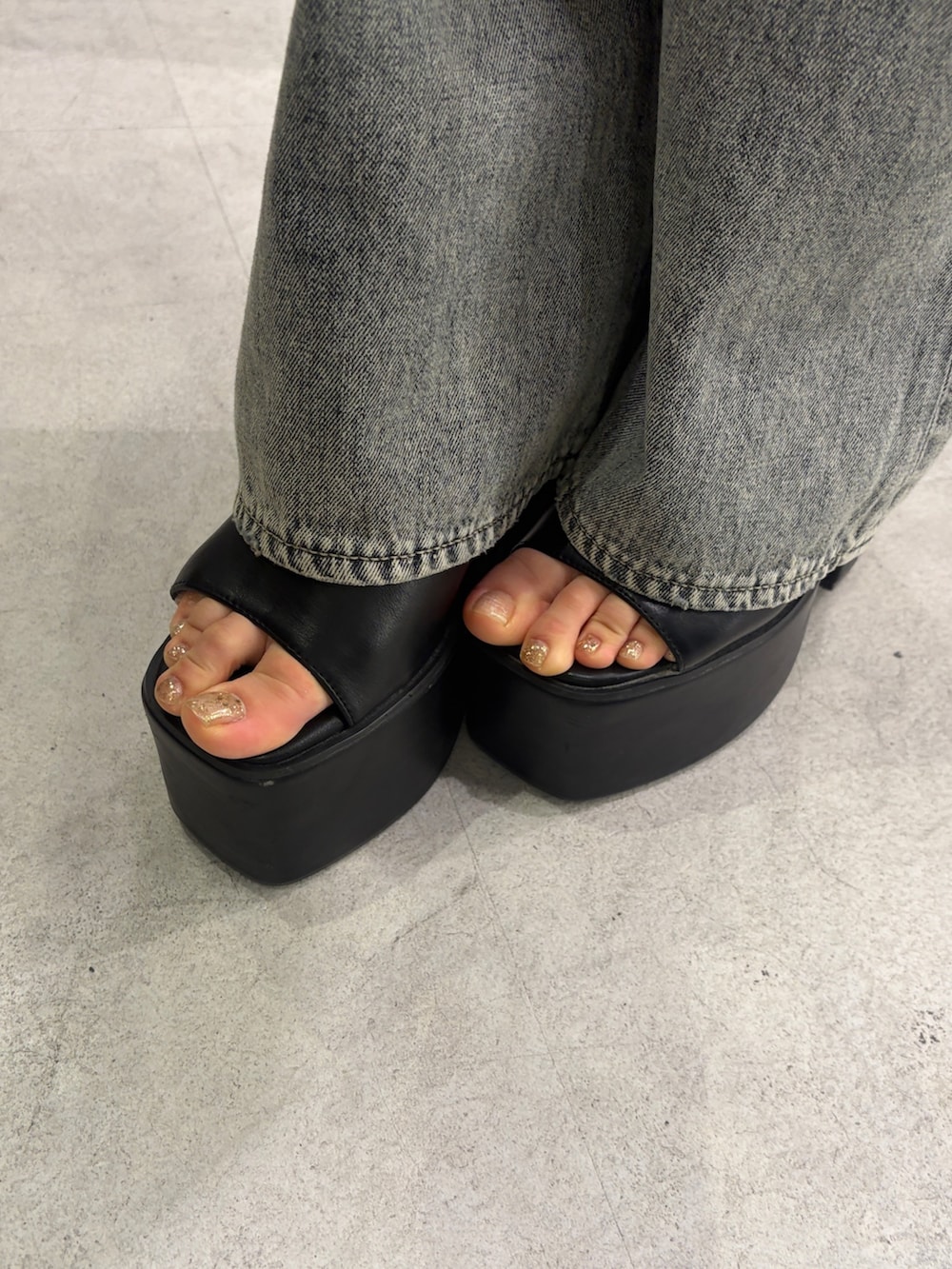 ピンク系のキャミソール、ブルー系のデニムパンツ、ブラック系のサンダルを着用したレディースの春コーディネートの6枚目の写真