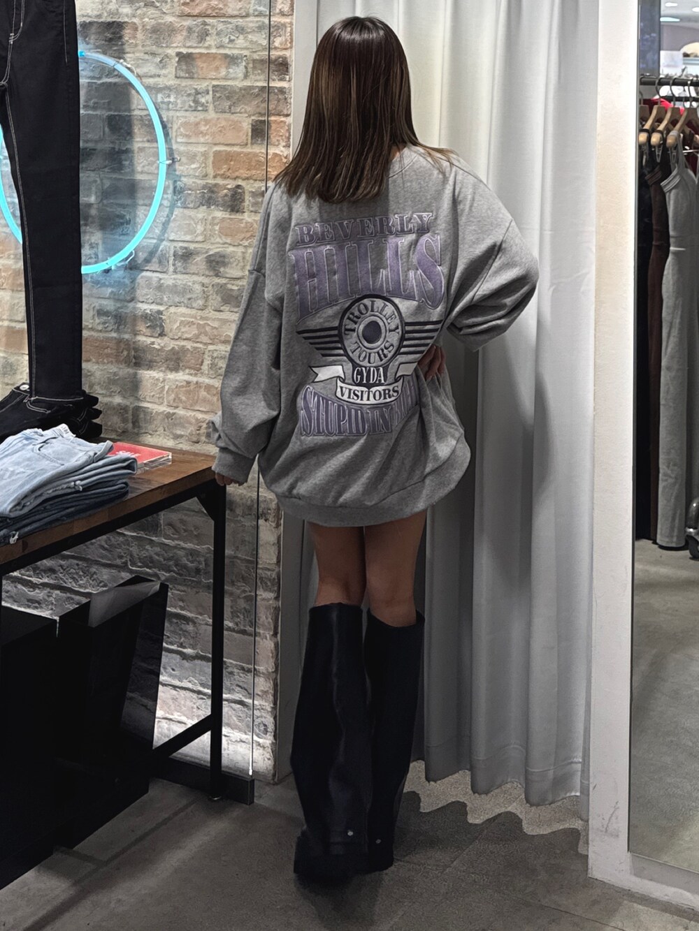 グレー系のスウェット、ブラック系のブーツを着用したレディースの夏コーディネートの2枚目の写真