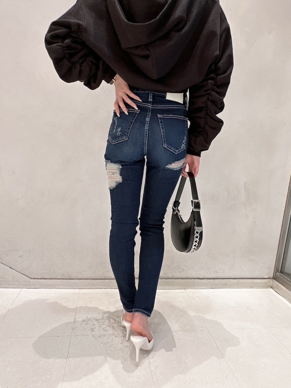 ブラック系のパーカー、ブルー系のデニムパンツ、ブルー系のデニムパンツを着用したレディースの冬コーディネートの4枚目の写真