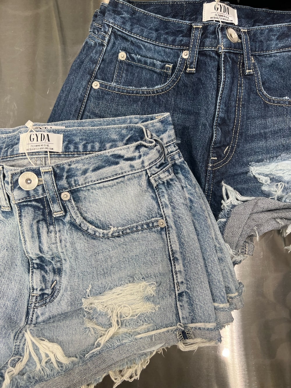 グレー系のカーディガン/ボレロ、ホワイト系のキャミソール、ブルー系のデニムパンツを着用したレディースの春コーディネートの6枚目の写真