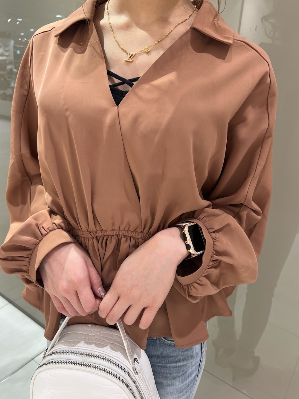 オレンジ系のシャツ/ブラウス、ブルー系のデニムパンツ、ブラック系のパンプスを着用したレディースの冬コーディネートの3枚目の写真