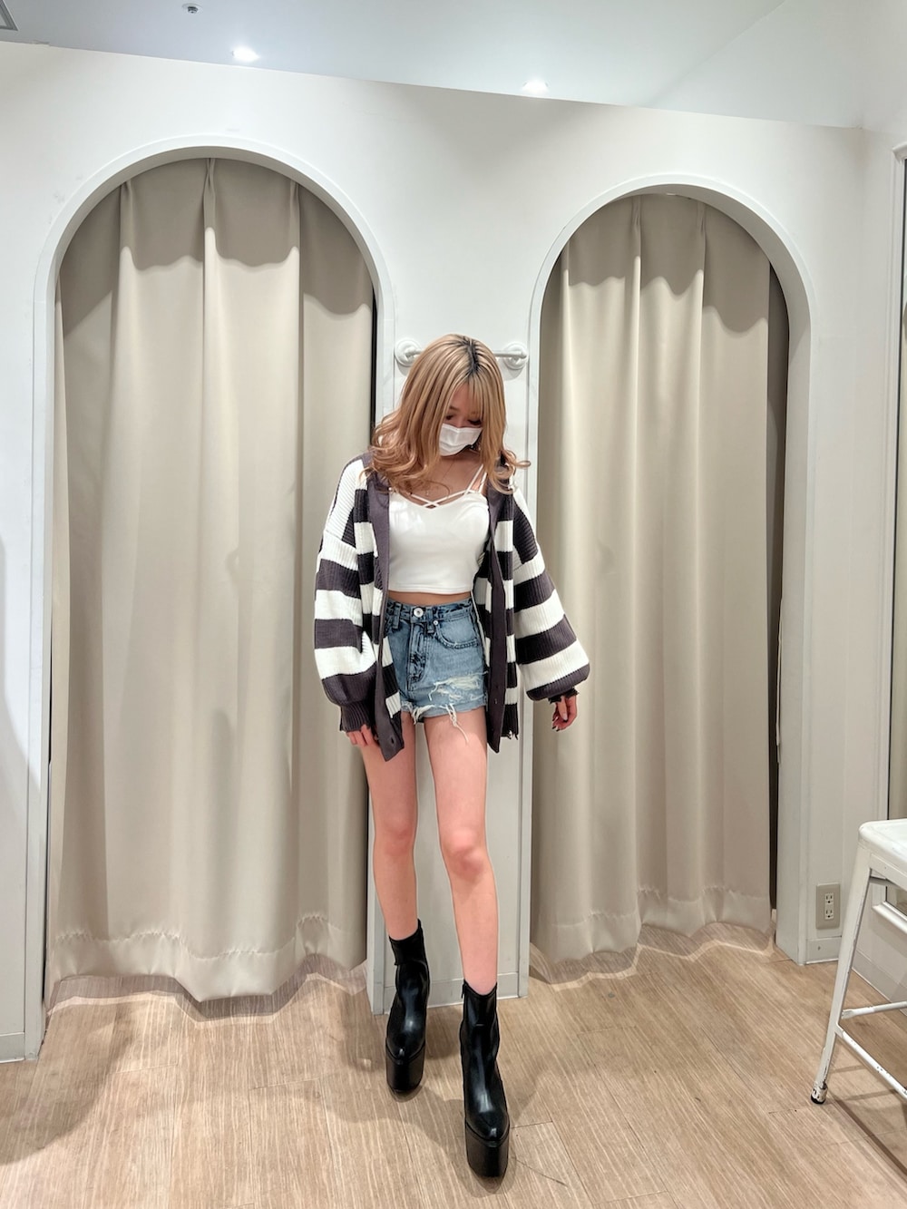 グレー系のカーディガン/ボレロ、ホワイト系のキャミソール、ブルー系のデニムパンツを着用したレディースの春コーディネートの3枚目の写真