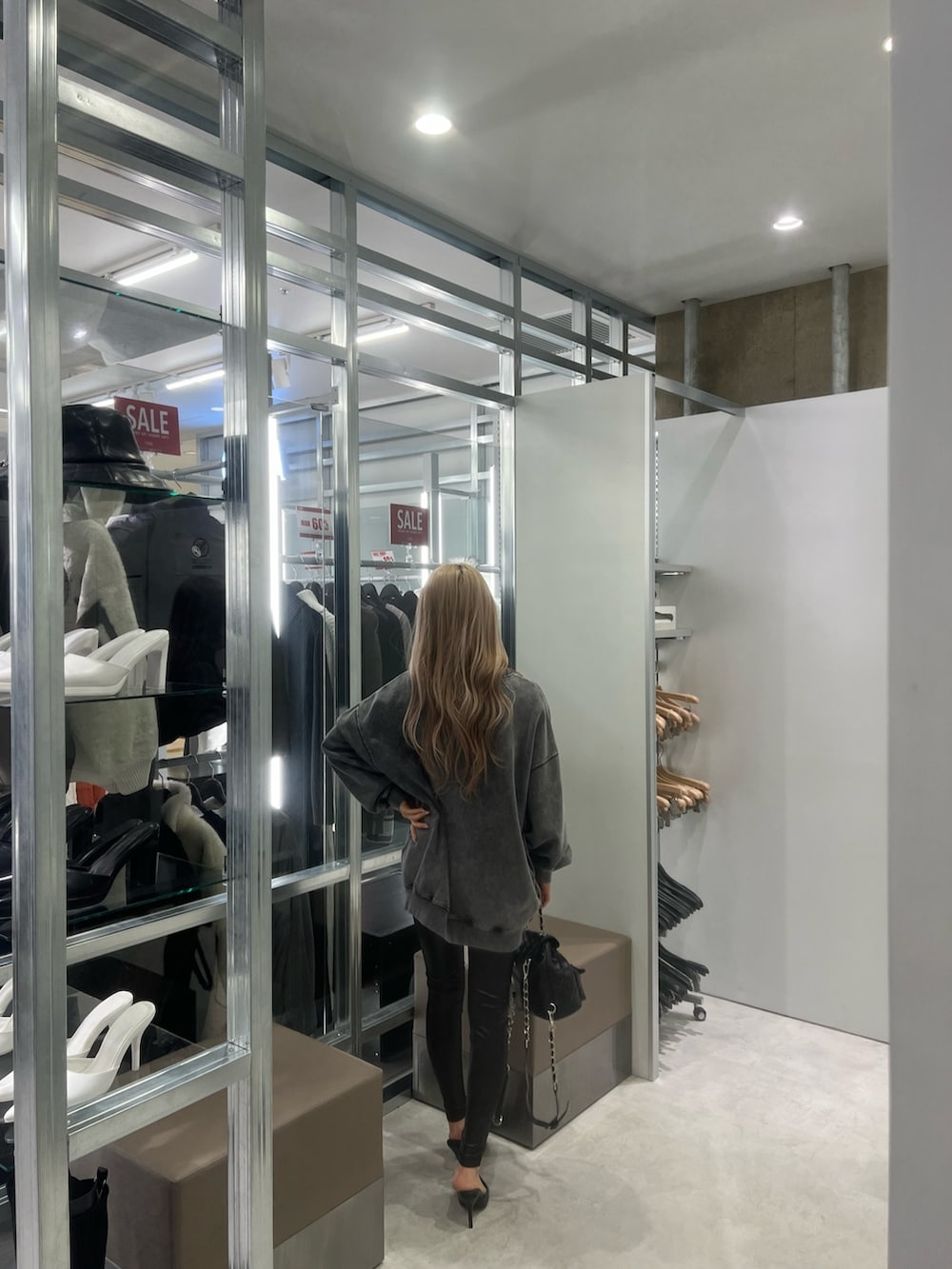 グレー系のスウェット、ブラック系のパンプス、ブラック系のレギンス/スパッツを着用したレディースの冬コーディネートの2枚目の写真