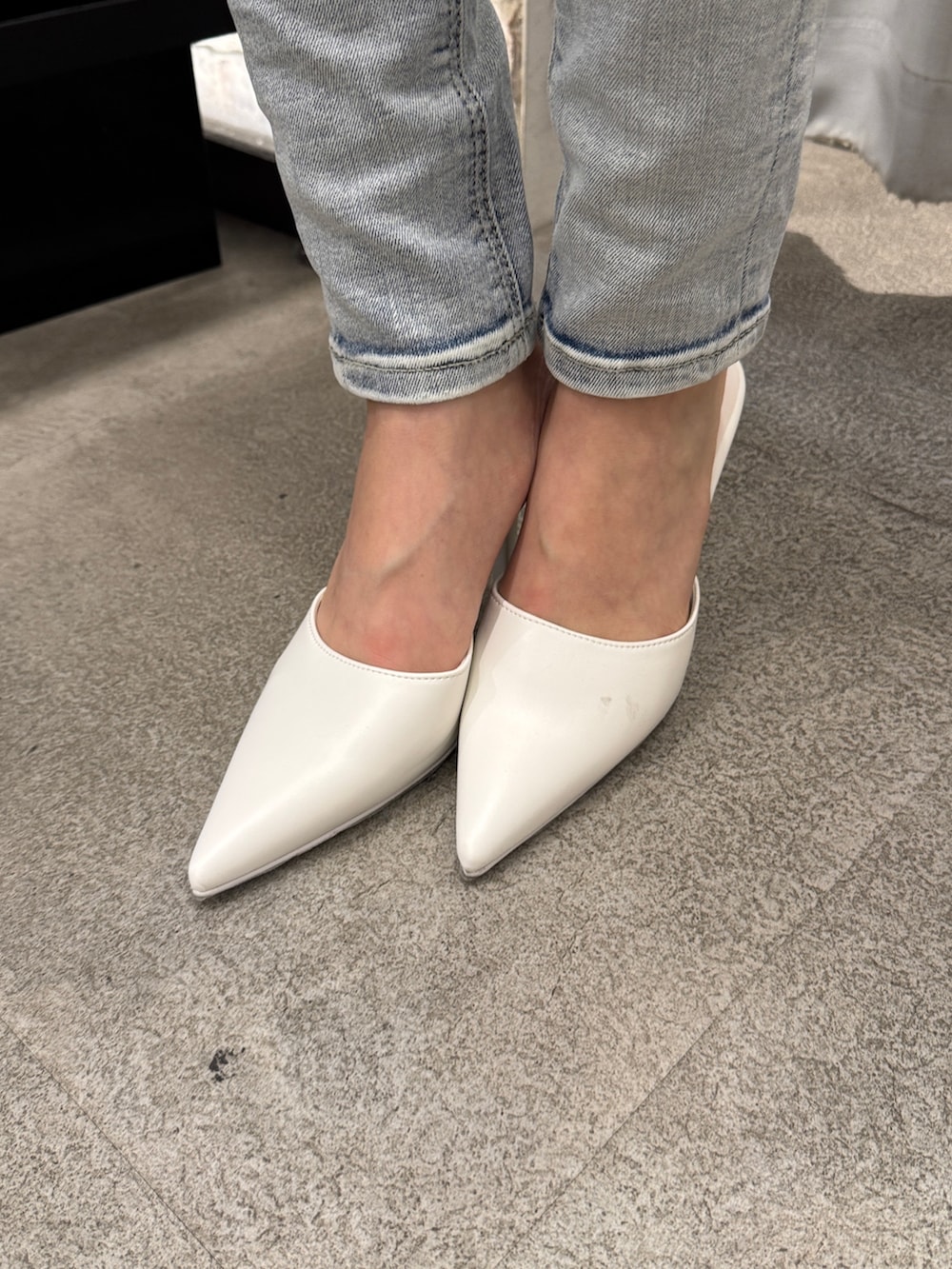 ホワイト系のキャミソール、ブルー系のデニムパンツ、ホワイト系のパンプスを着用したレディースの春コーディネートの6枚目の写真