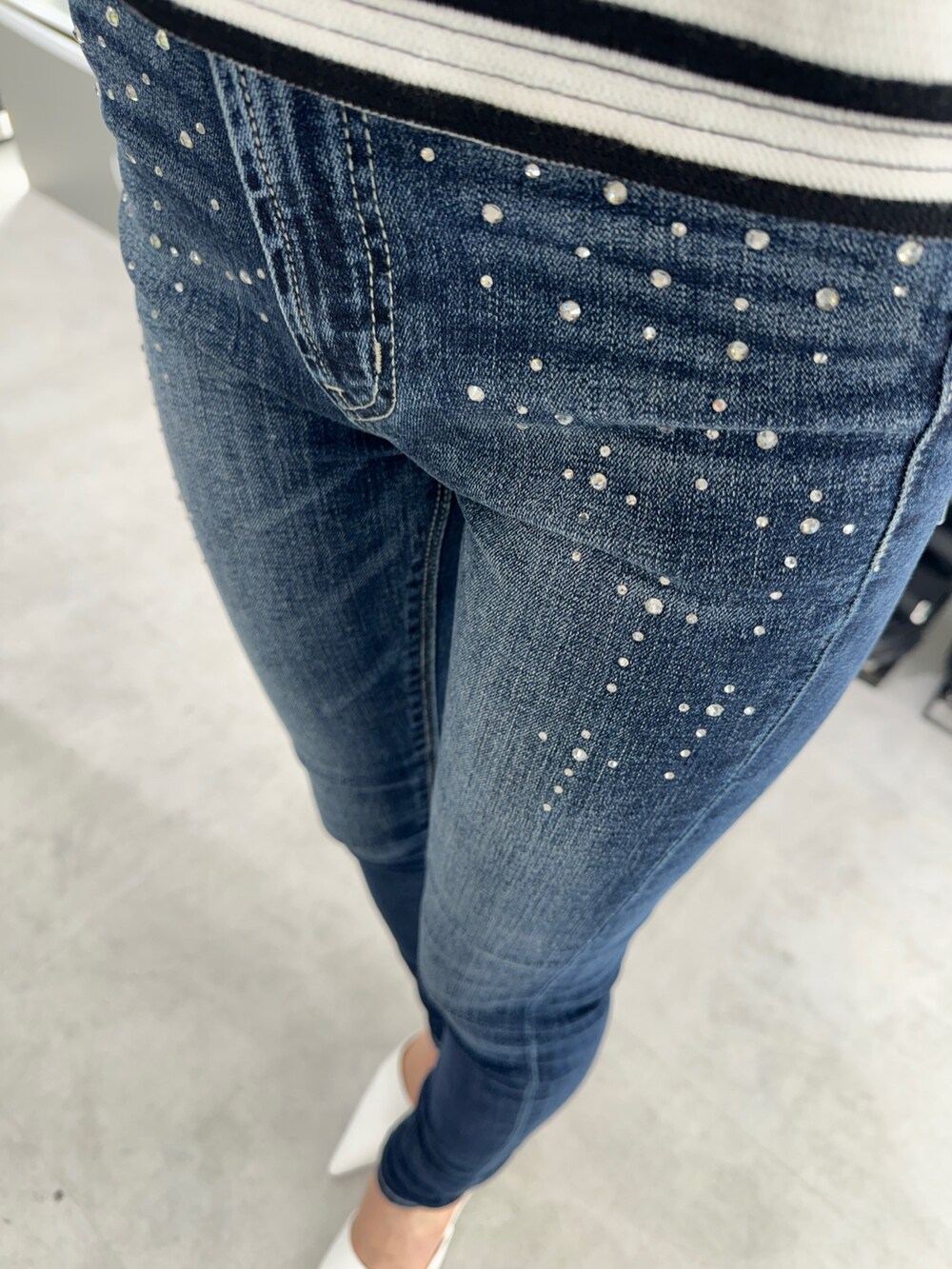 その他のキャミソール、ブルー系のデニムパンツ、ホワイト系のパンプスを着用したレディースの春コーディネートの6枚目の写真
