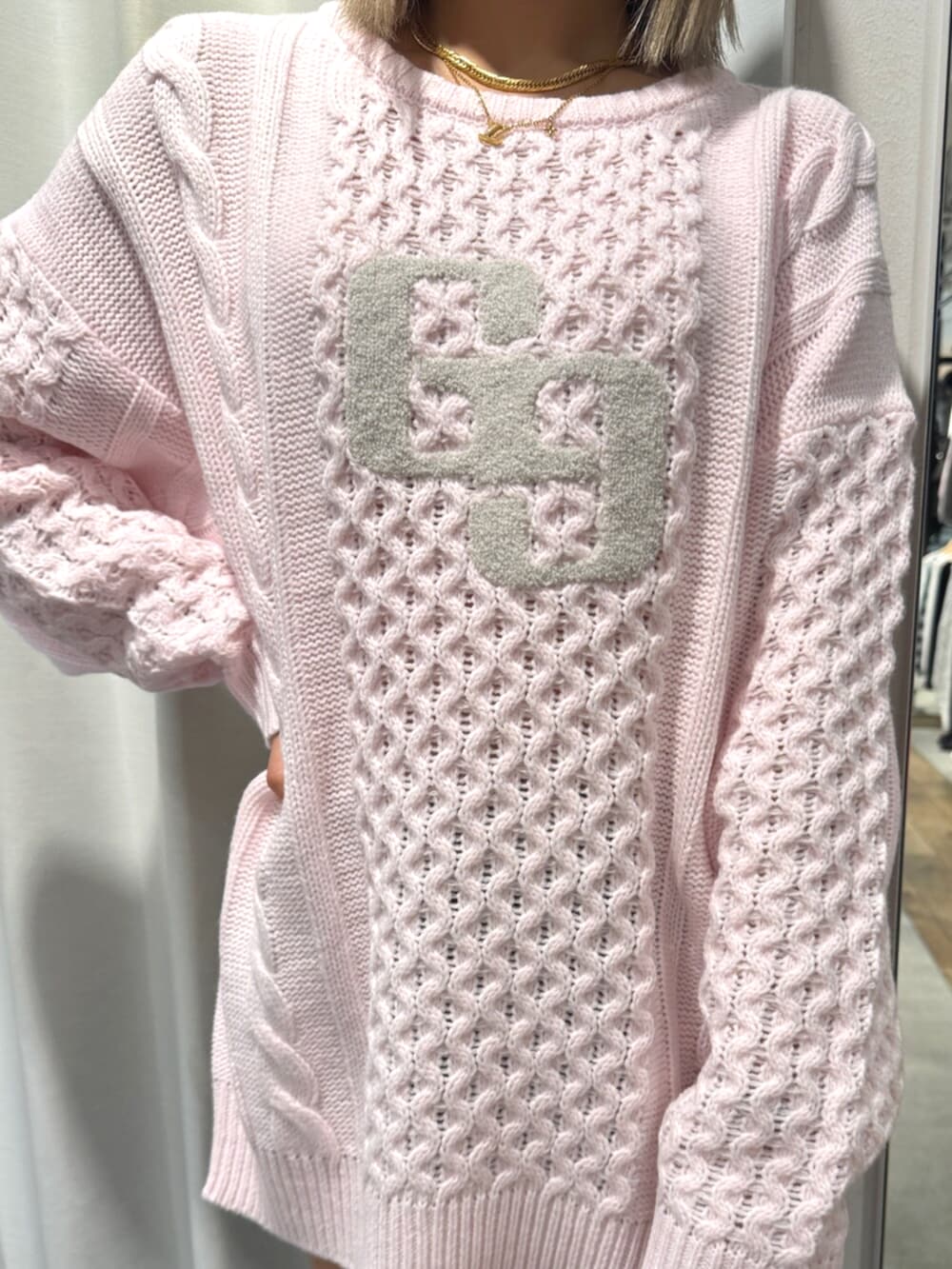 ピンク系のニット/セーター、ブラック系のブーツを着用したレディースの秋コーディネートの4枚目の写真