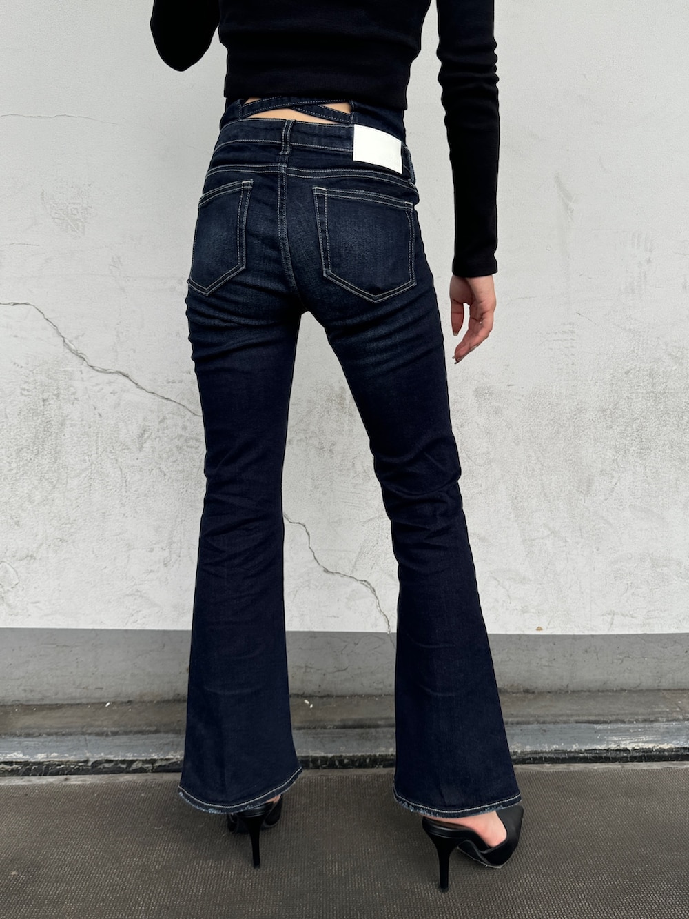 ブラック系のTシャツ/カットソー、ブルー系のデニムパンツ、ブラック系のパンプスを着用したレディースの秋コーディネートの5枚目の写真