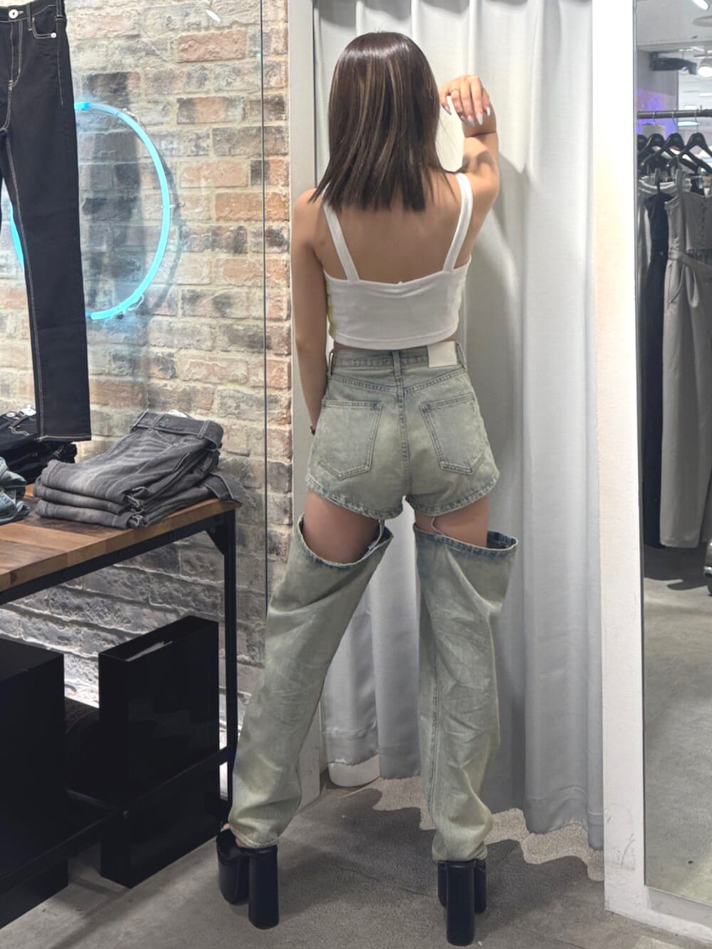 ブラック系のサンダル、ホワイト系のキャミソール、ブルー系のデニムパンツを着用したレディースの夏コーディネートの3枚目の写真