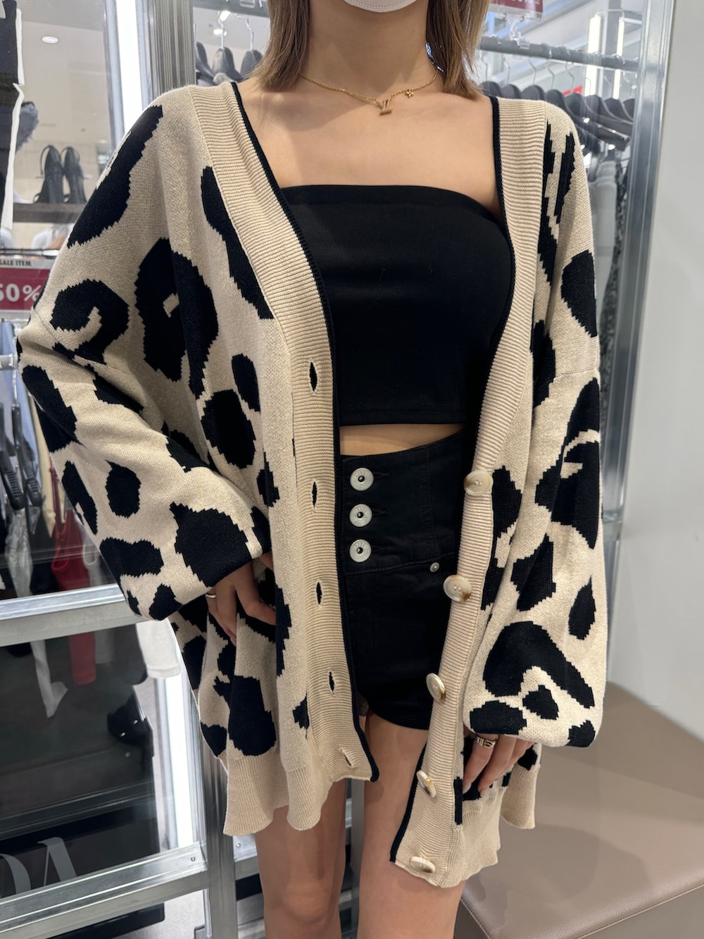 ブラック系のチューブトップ、ベージュ系のカーディガン/ボレロ、ブラック系のその他パンツを着用したレディースの夏コーディネートの4枚目の写真