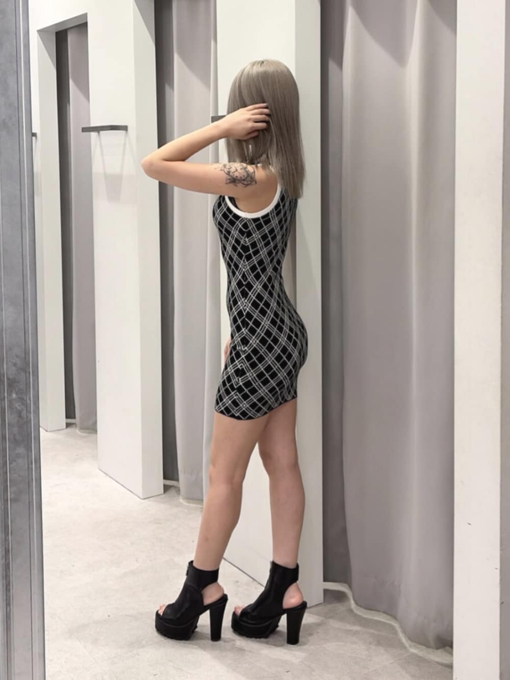 ブラック系のワンピース、ブラック系のブーツを着用したレディースの夏コーディネートの3枚目の写真