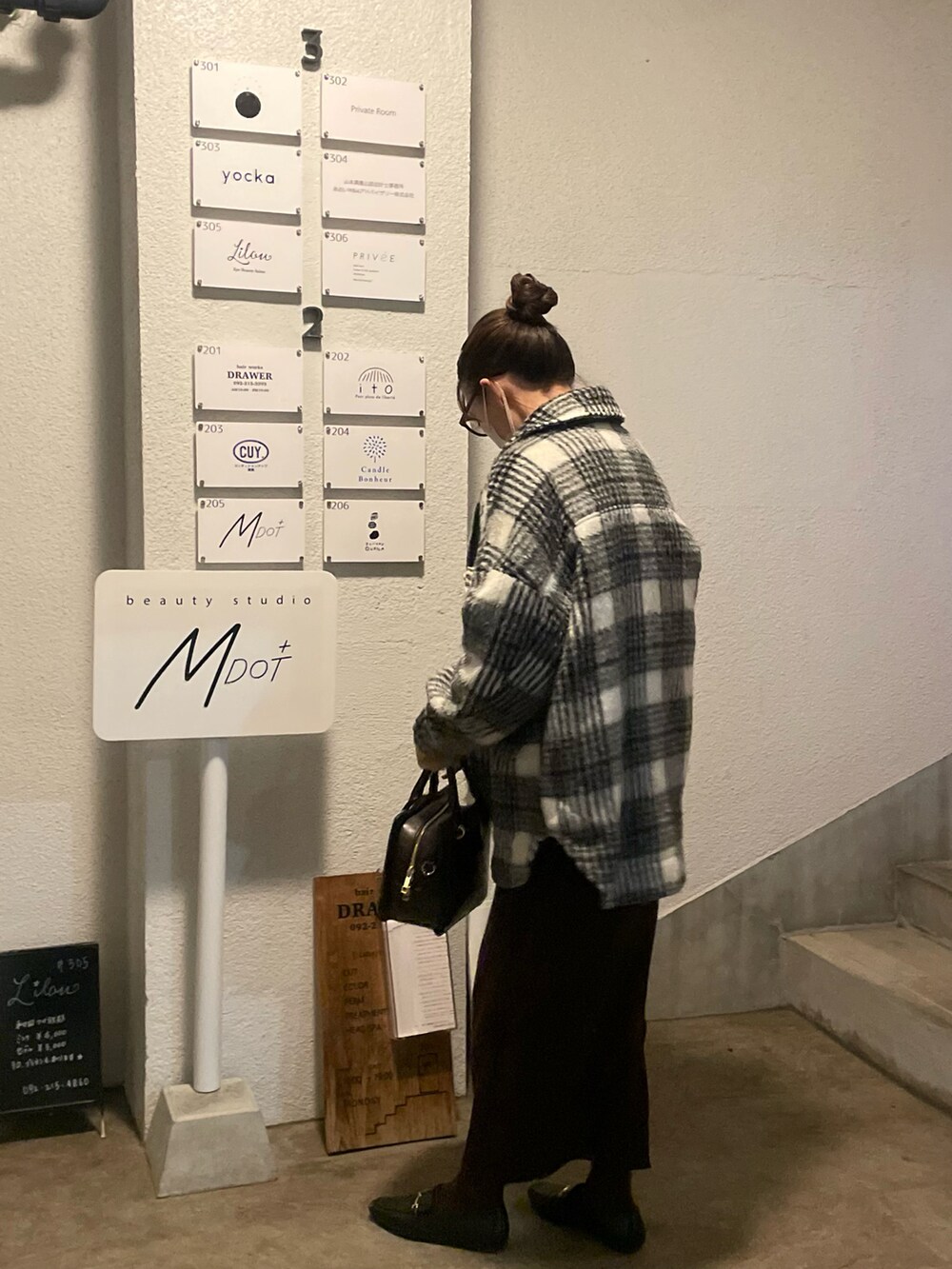 ブラウン系のスカート、その他のジャケット/アウター、イエロー系のニット/セーターを着用したレディースの冬コーディネートの2枚目の写真