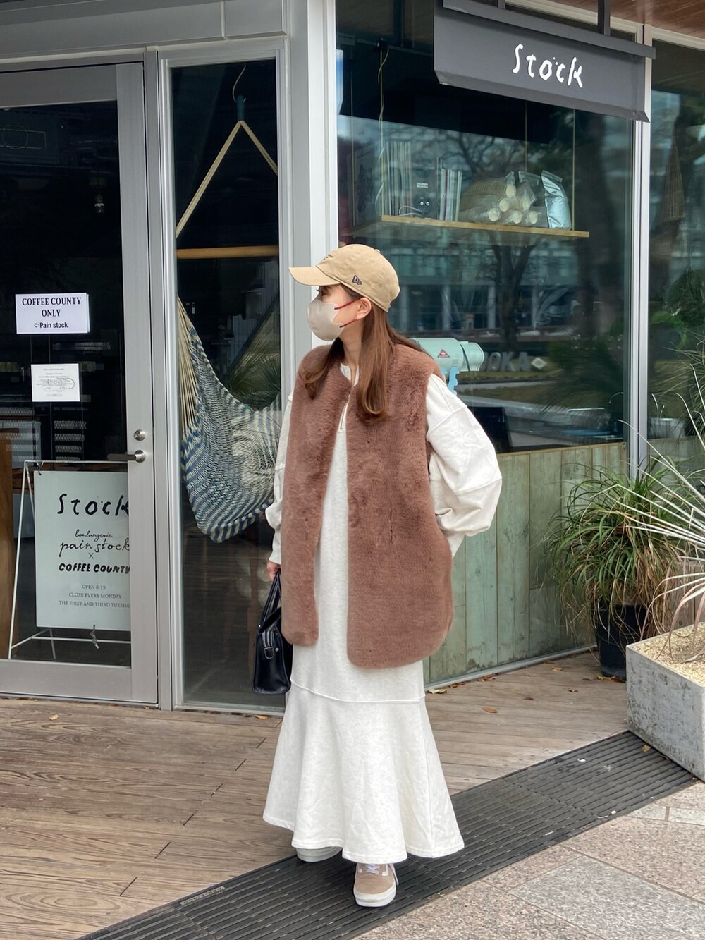 ベージュ系のワンピース、ベージュ系のキャップを着用したレディースの冬コーディネートの2枚目の写真