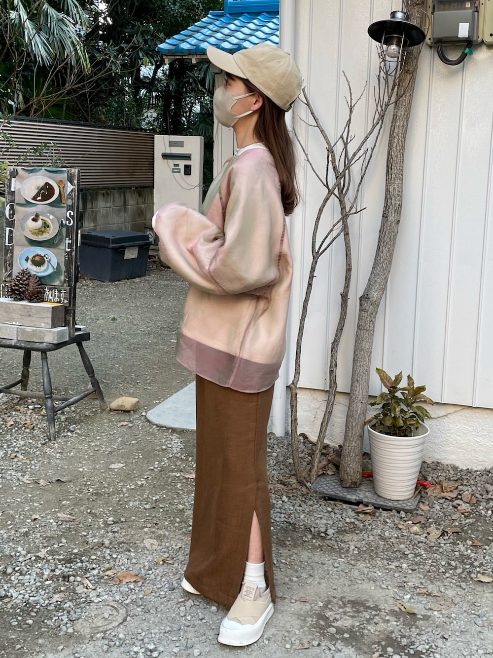 ピンク系のスウェット、ブラウン系のスカート、ベージュ系のスニーカーを着用したレディースの冬コーディネートの2枚目の写真