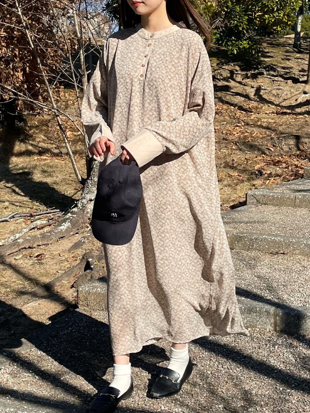 ベージュ系のワンピース、ブラック系のローファーを着用したレディースの冬コーディネートの2枚目の写真