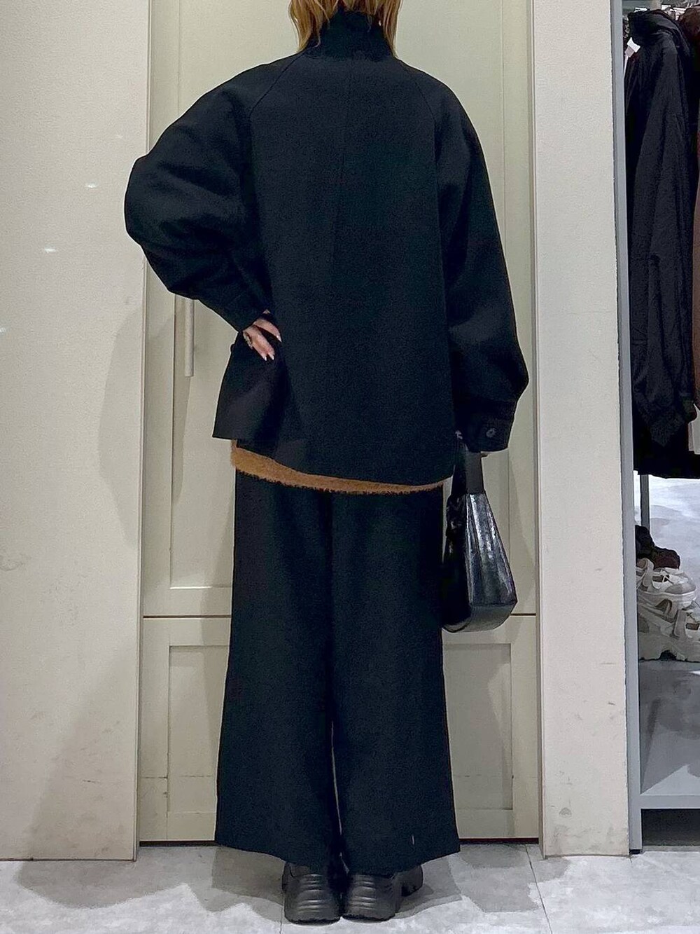 ブラック系のブーツ、ブラック系のその他パンツ、ブラック系のショルダーバッグを着用したレディースの冬コーディネートの6枚目の写真