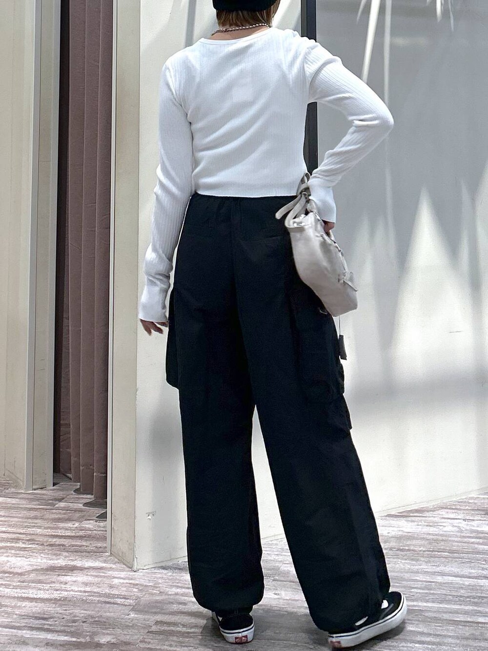 ホワイト系のニット/セーター、ブラック系のカーゴパンツ、ベージュ系のボストンバッグを着用したレディースの春コーディネートの6枚目の写真