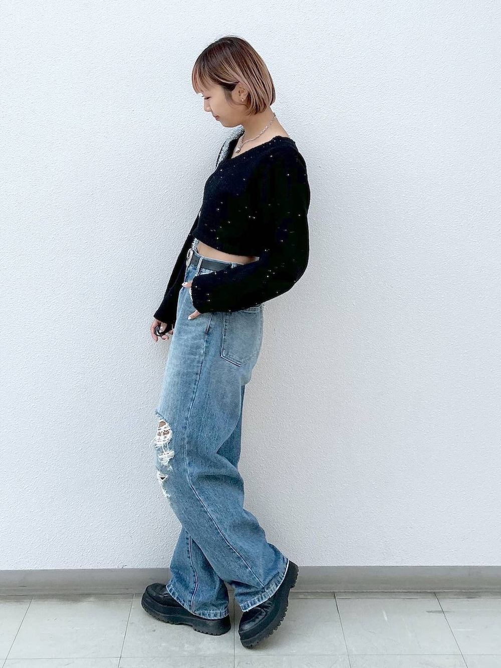 ブラック系のブーツ、ブルー系のデニムパンツ、シルバー系のトートバッグを着用したレディースの冬コーディネートの2枚目の写真