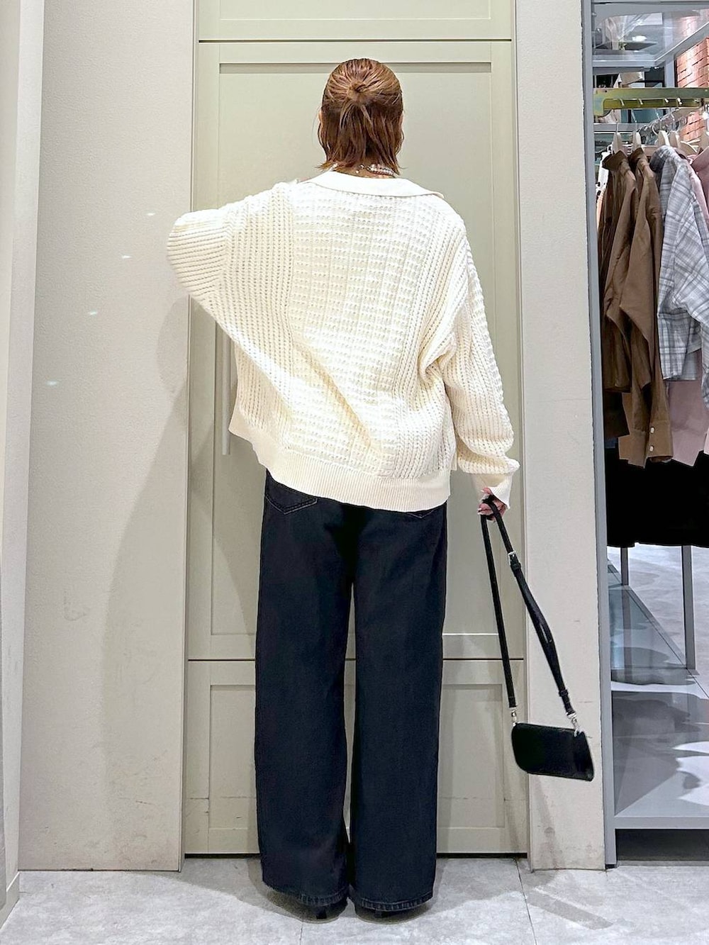 ブラック系のデニムパンツ、ブラック系のサンダル、ブラック系のボディバッグ/ウエストポーチを着用したレディースの春コーディネートの3枚目の写真