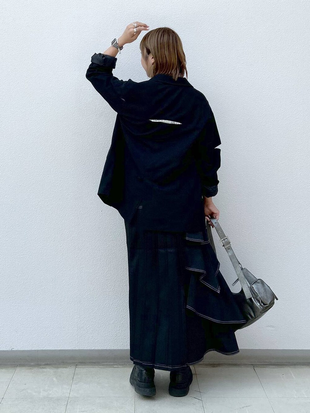 ブラック系のテーラードジャケット、ブラック系のブーツ、ベージュ系のTシャツ/カットソーを着用したレディースの秋コーディネートの3枚目の写真