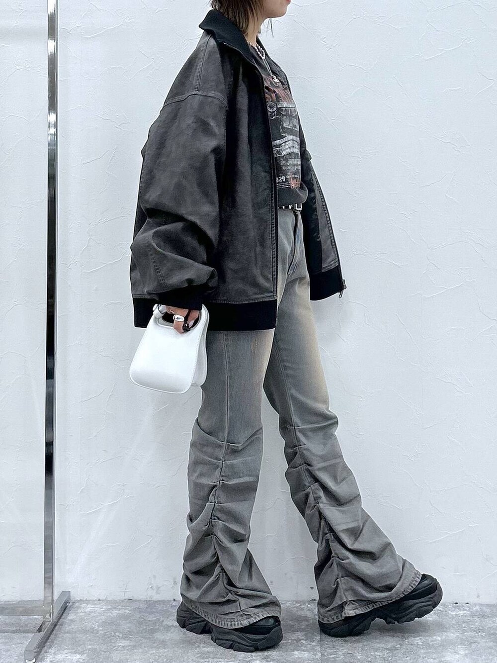 ブラック系のスニーカー、ブルー系のデニムパンツ、ブラック系のブルゾンを着用したレディースの秋コーディネートの5枚目の写真