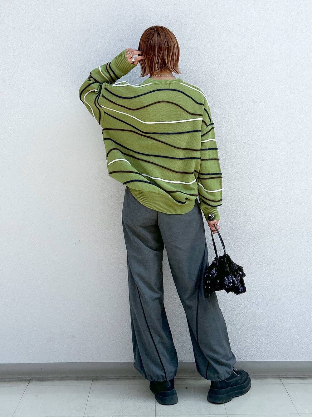 グレー系のその他パンツ、ブラック系のブーツ、グリーン系のニット/セーターを着用したレディースの冬コーディネートの3枚目の写真