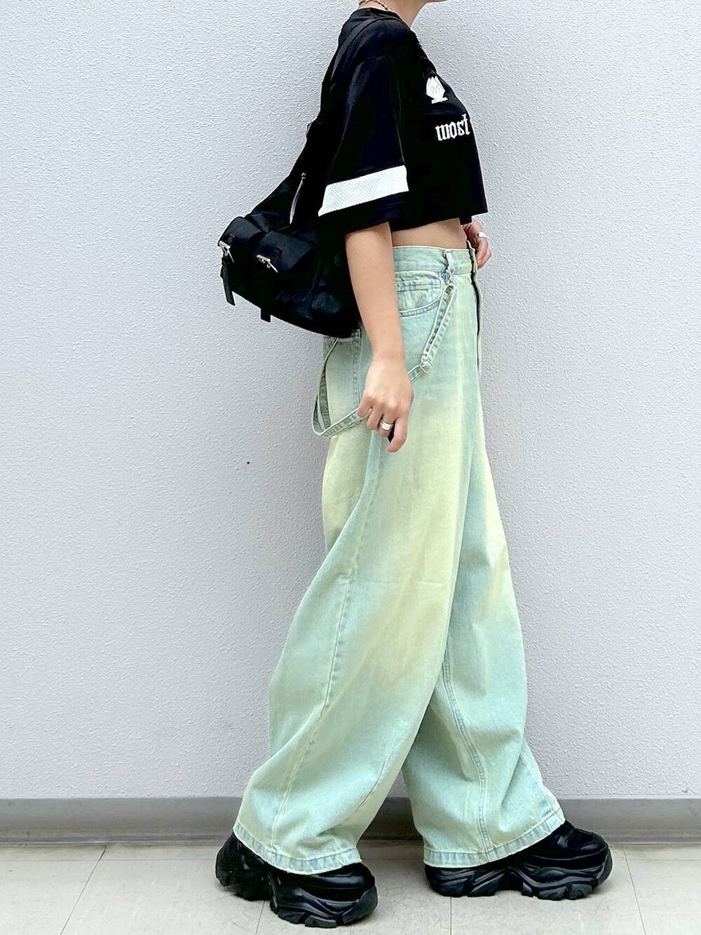 ブラック系のショルダーバッグ、ブラック系のスニーカー、ブラック系のTシャツ/カットソーを着用したレディースの春コーディネートの5枚目の写真