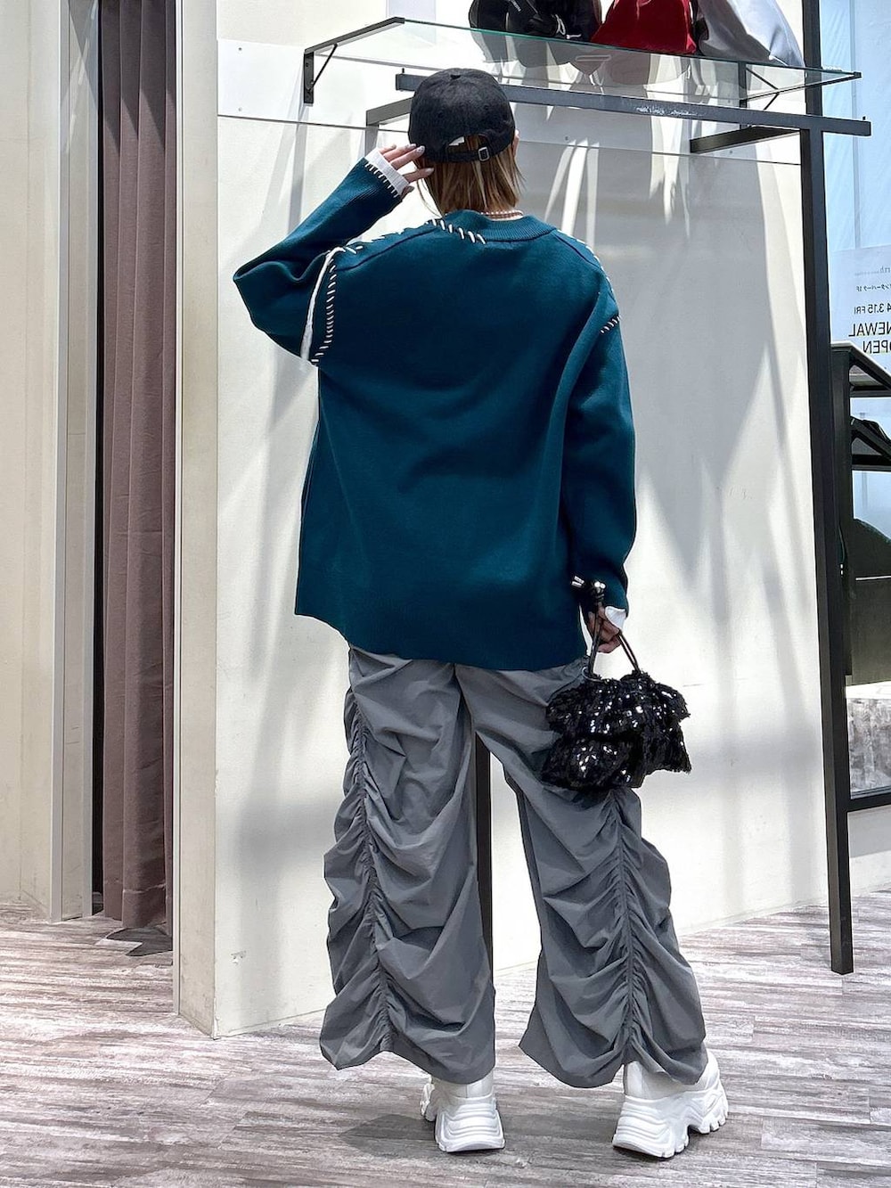 ホワイト系のニット/セーター、グレー系のその他パンツ、ブルー系のカーディガン/ボレロを着用したレディースの春コーディネートの3枚目の写真