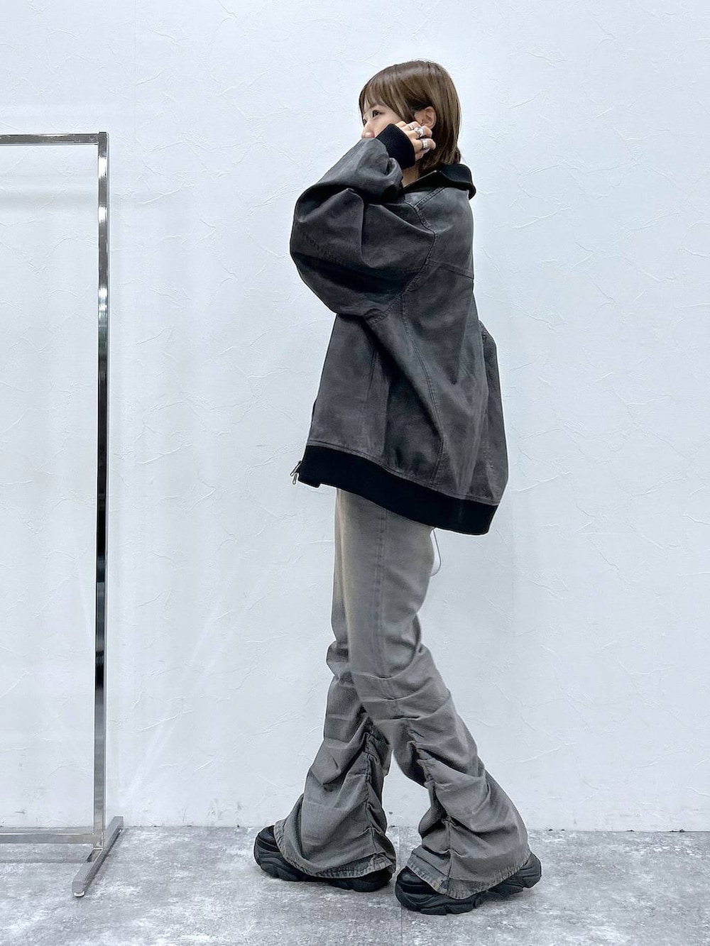 ブラック系のスニーカー、ブルー系のデニムパンツ、ブラック系のブルゾンを着用したレディースの秋コーディネートの2枚目の写真