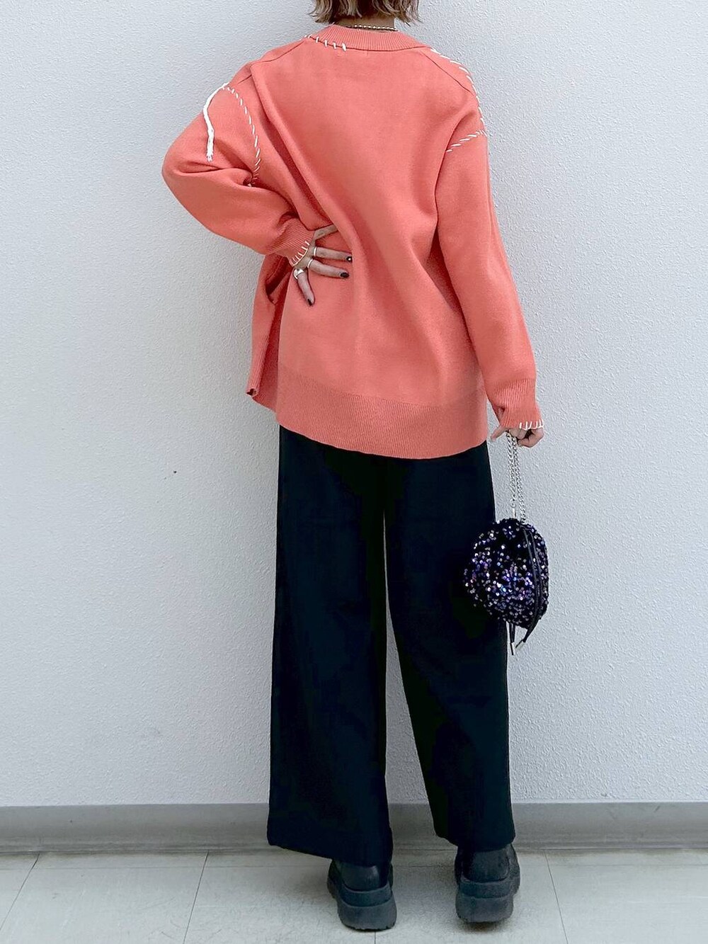 ブラック系のスラックス、ホワイト系のタンクトップ、ブラック系のブーツを着用したレディースの冬コーディネートの6枚目の写真