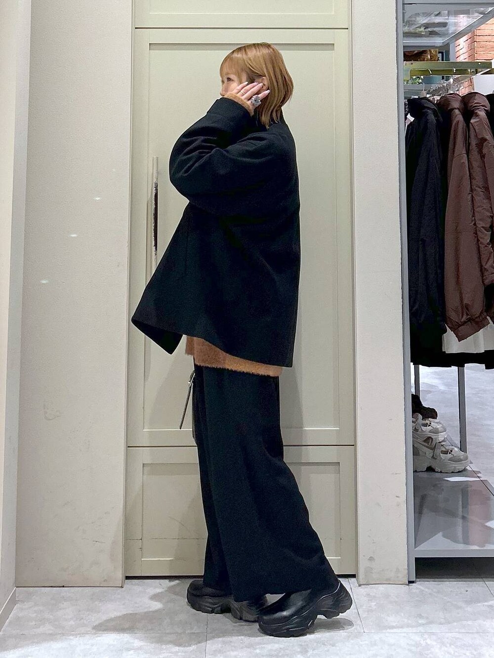 ブラック系のブーツ、ブラック系のその他パンツ、ブラック系のショルダーバッグを着用したレディースの冬コーディネートの2枚目の写真