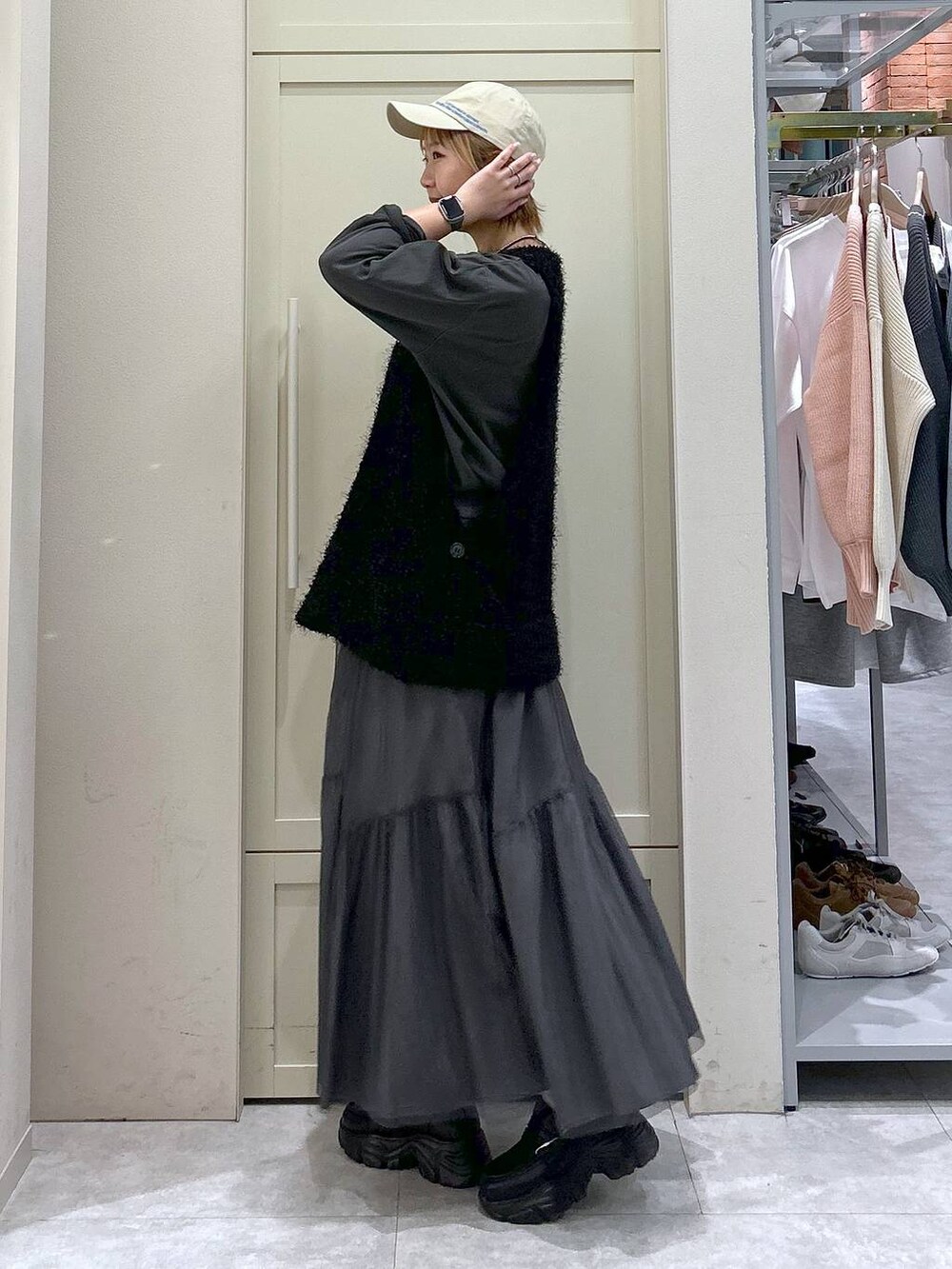 ブラック系のショルダーバッグ、ブラック系のローファー、ブラック系のベストを着用したレディースの春コーディネートの2枚目の写真