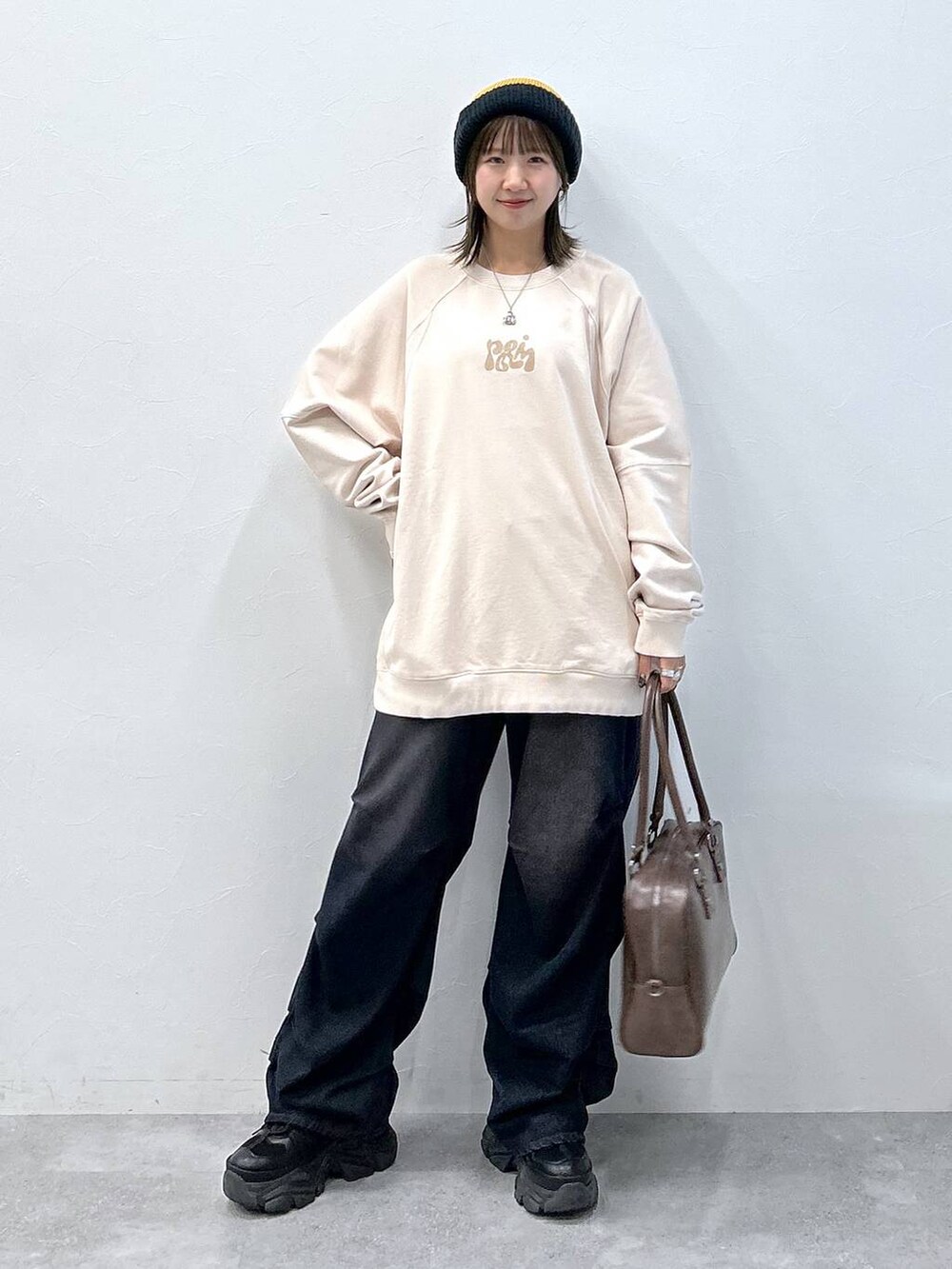 ブラック系のスニーカー、ブルー系のデニムパンツ、ブラウン系のボストンバッグを着用したレディースの冬コーディネートの7枚目の写真