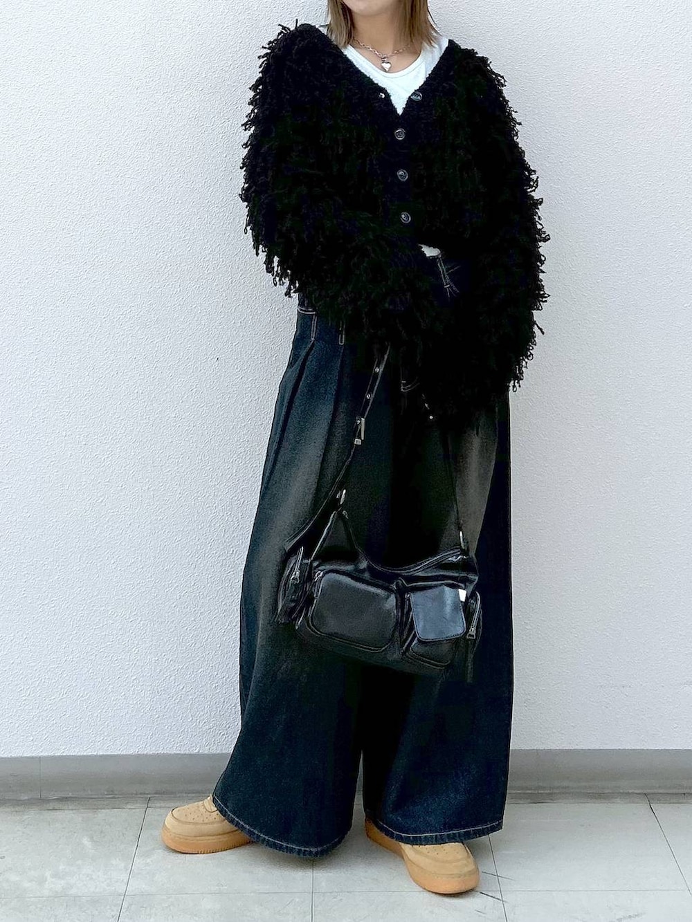 ブラック系のショルダーバッグ、ブラック系のカーディガン/ボレロ、ホワイト系のTシャツ/カットソーを着用したレディースの冬コーディネートの4枚目の写真