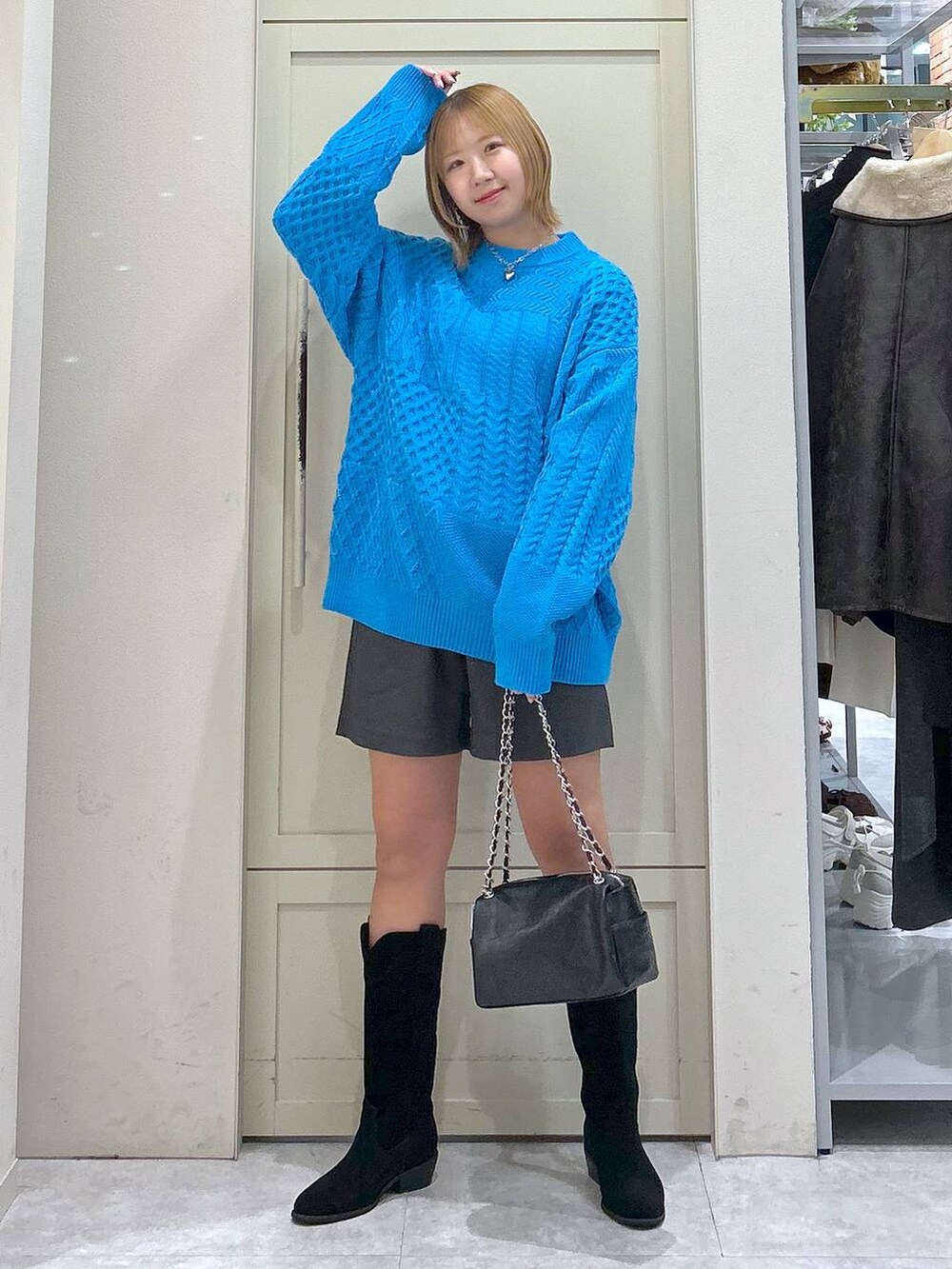 グレー系のその他パンツ、ブルー系のニット/セーター、ブラック系のショルダーバッグを着用したレディースの冬コーディネートの7枚目の写真