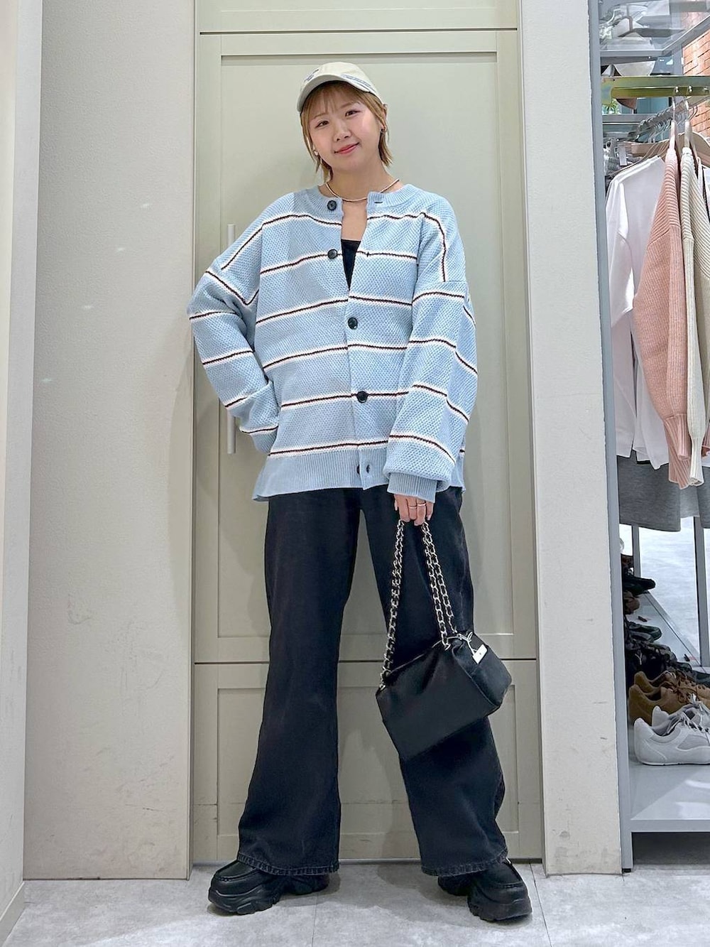 ブラック系のデニムパンツ、ブラック系のショルダーバッグ、ブラック系のローファーを着用したレディースの冬コーディネートの7枚目の写真