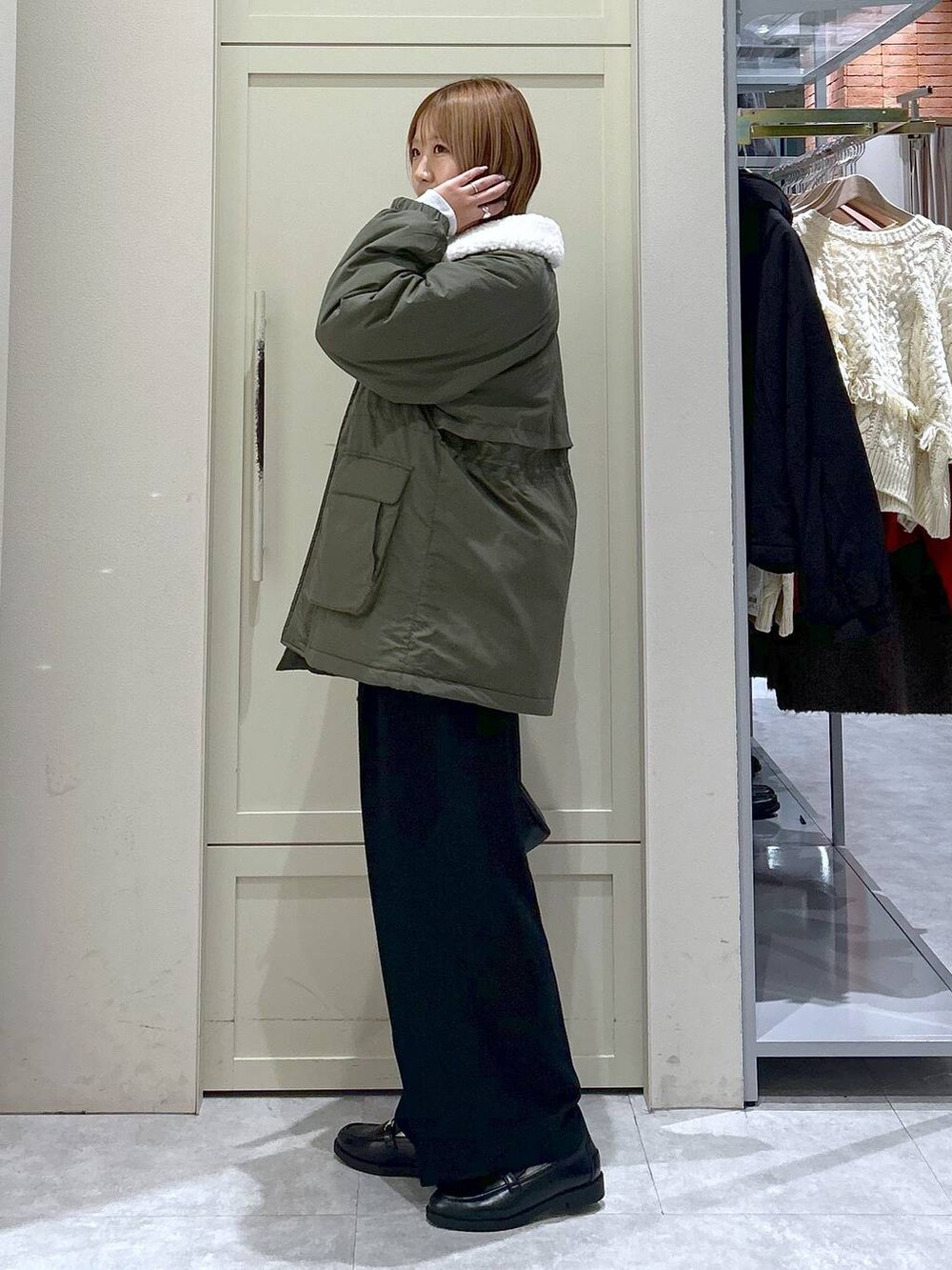 ブラック系のスラックス、グリーン系のその他アウター、ブラック系のローファーを着用したレディースの冬コーディネートの2枚目の写真