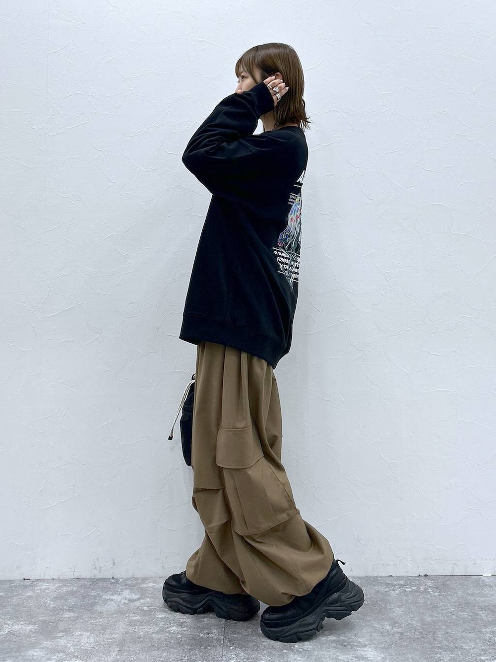 ブラック系のスニーカー、ブラック系のスウェット、ブラック系のショルダーバッグを着用したレディースの秋コーディネートの2枚目の写真