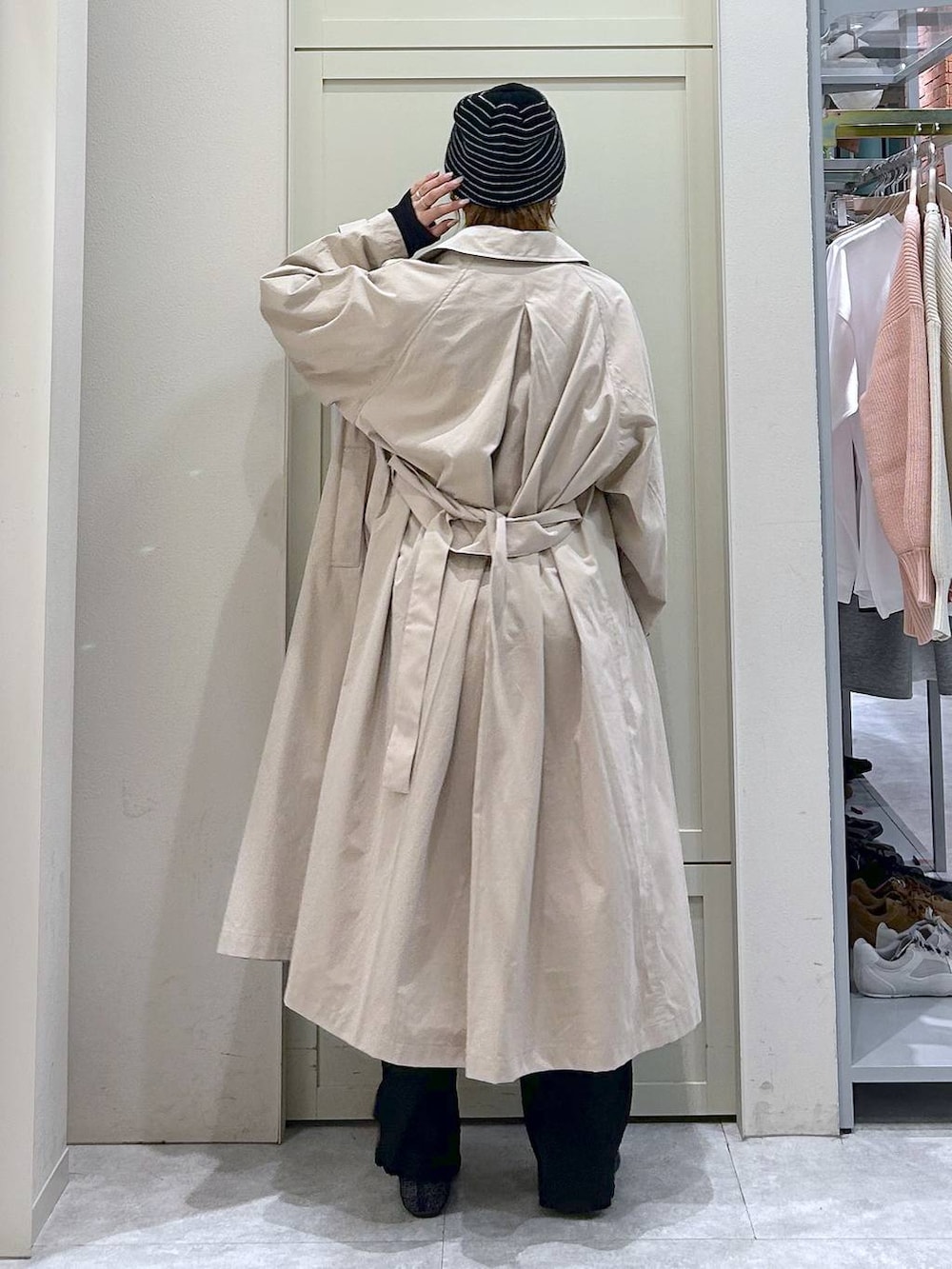 ブラック系のショルダーバッグ、ブラック系のパンプス、ベージュ系のステンカラーコートを着用したレディースの春コーディネートの3枚目の写真