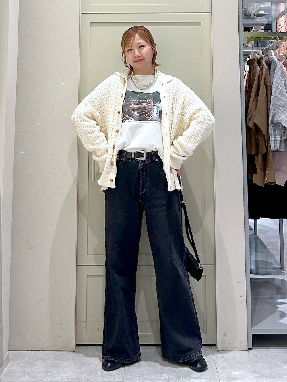 ブラック系のデニムパンツ、ブラック系のサンダル、ブラック系のボディバッグ/ウエストポーチを着用したレディースの春コーディネートの7枚目の写真