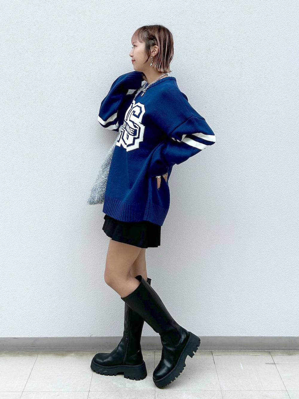 シルバー系のトートバッグ、ブラック系のブーツ、ブラック系のその他パンツを着用したレディースの秋コーディネートの2枚目の写真