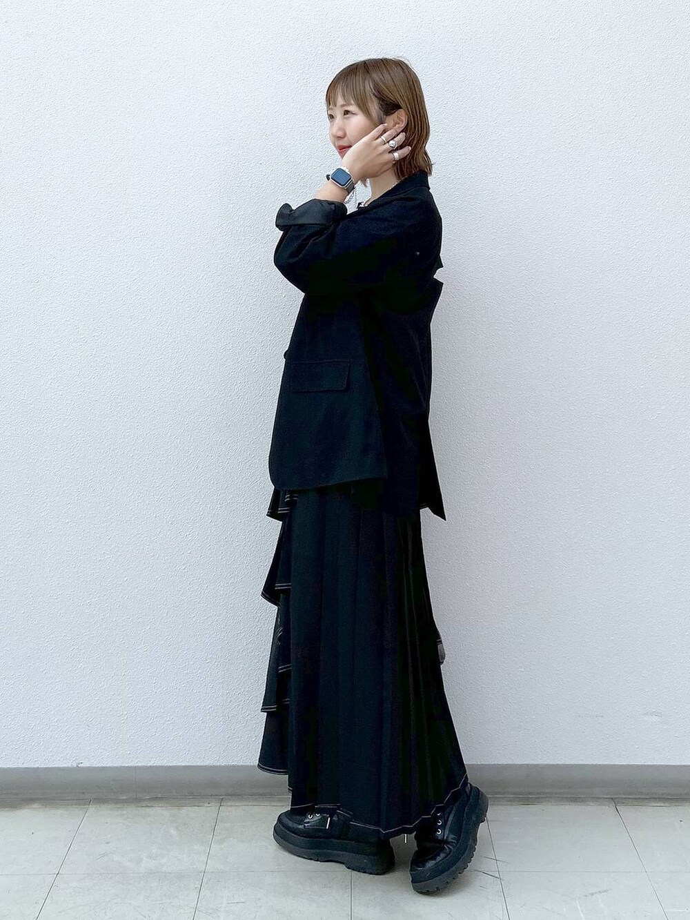 ブラック系のテーラードジャケット、ブラック系のブーツ、ベージュ系のTシャツ/カットソーを着用したレディースの秋コーディネートの2枚目の写真