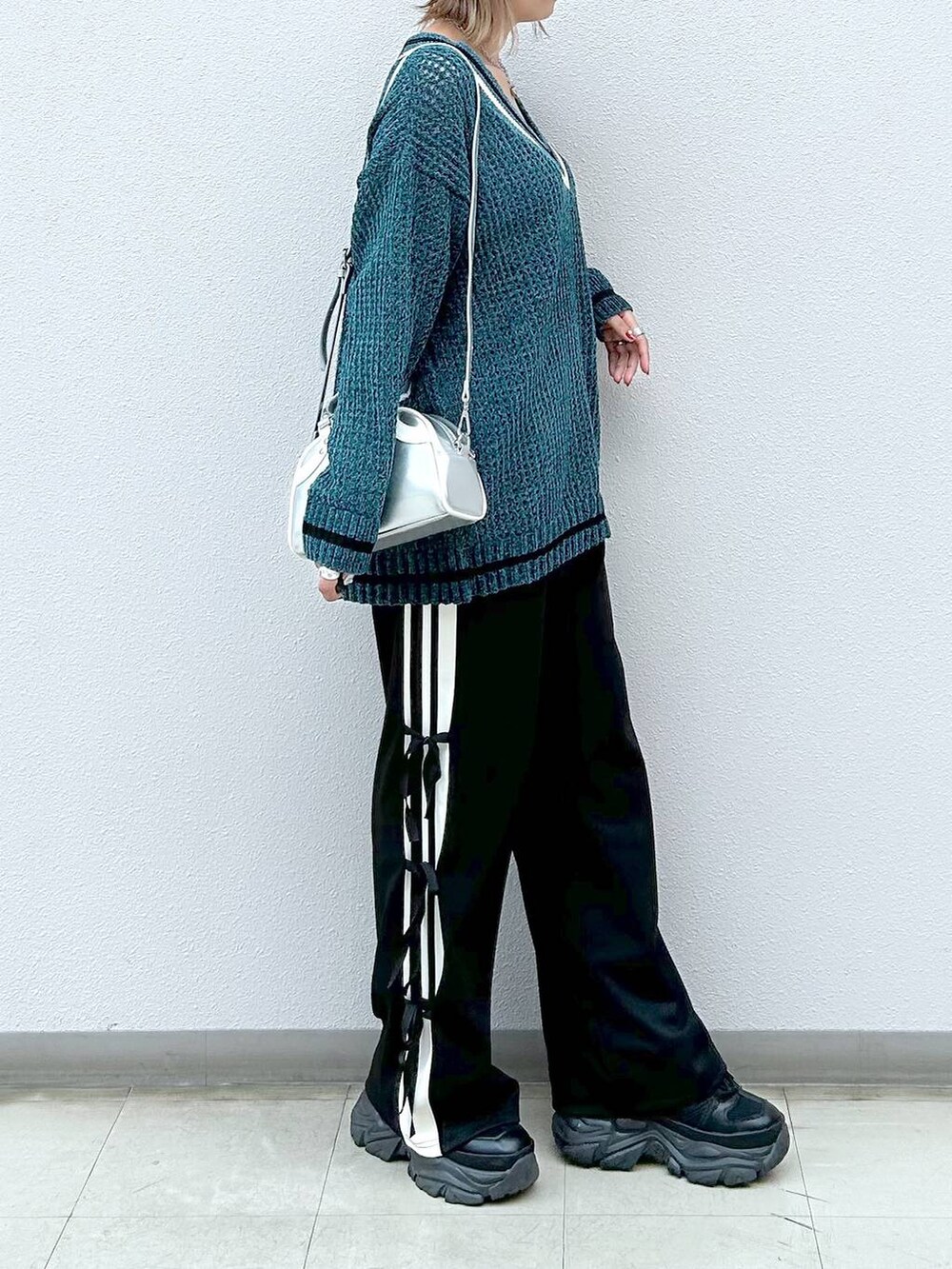 ブラック系のスニーカー、ブラック系のその他パンツ、シルバー系のショルダーバッグを着用したレディースの秋コーディネートの5枚目の写真
