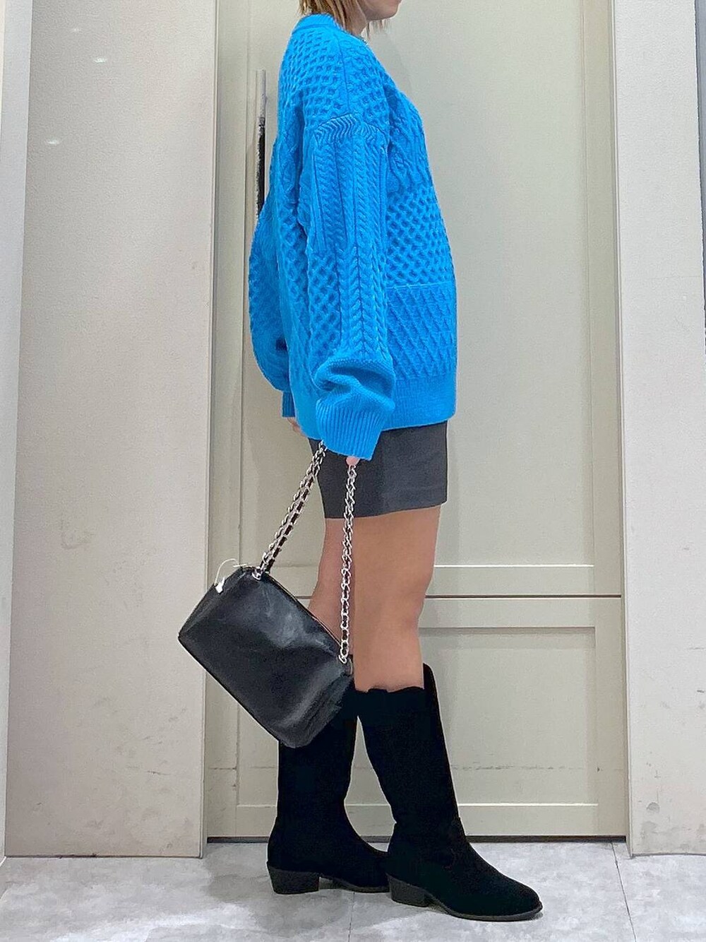 グレー系のその他パンツ、ブルー系のニット/セーター、ブラック系のショルダーバッグを着用したレディースの冬コーディネートの5枚目の写真